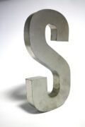 Close-up of a metallic letter S sculpture made of silver iron on a white background.